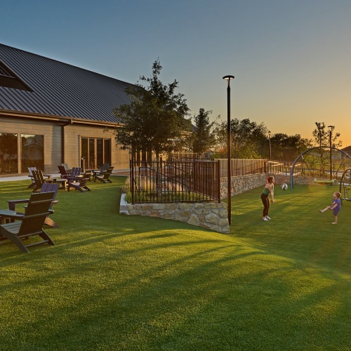 lush, green lawn with a playground and seating at sunset in Princeton